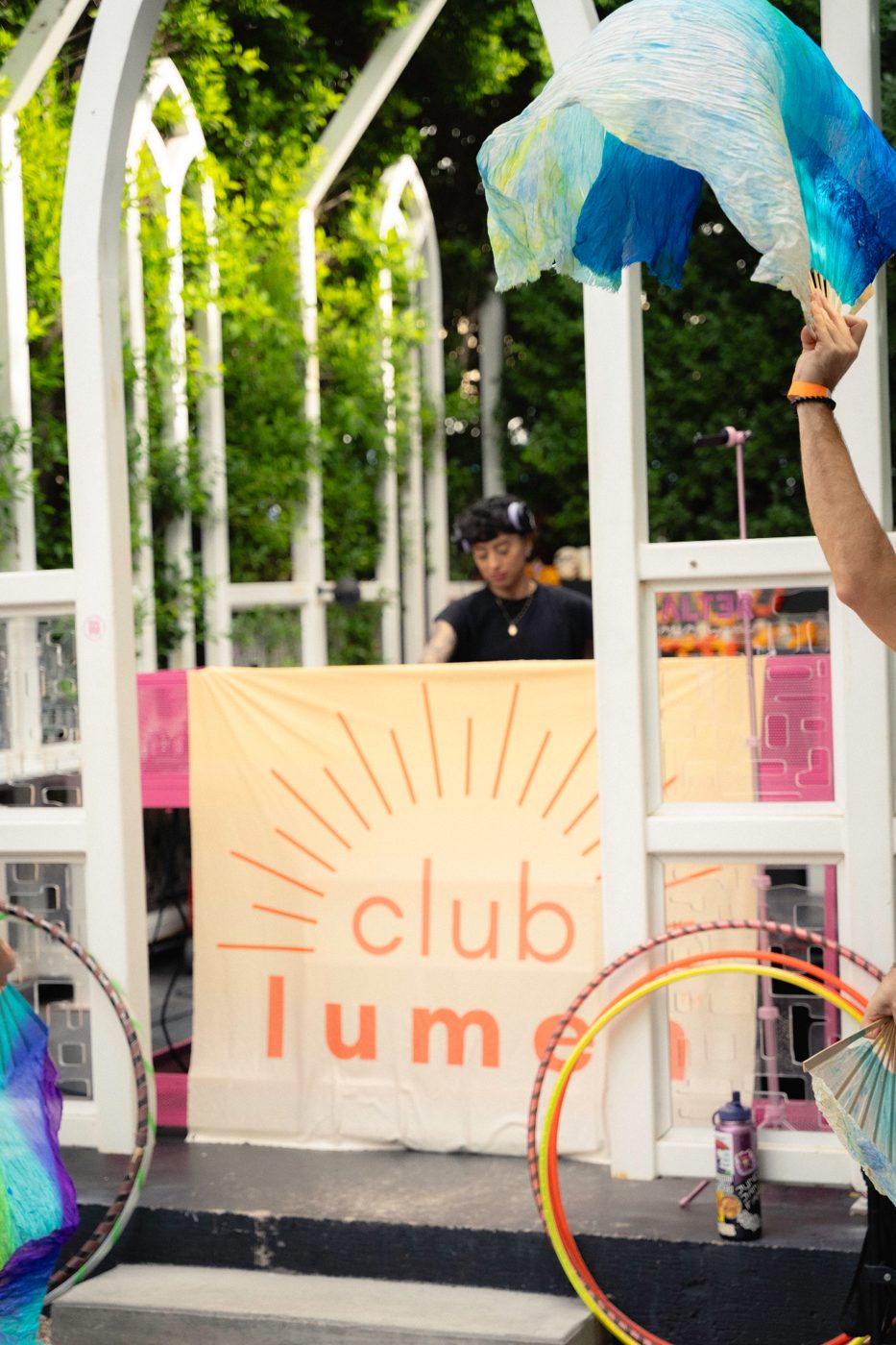 Club Lumen branded stage backdrop with a performer at the event