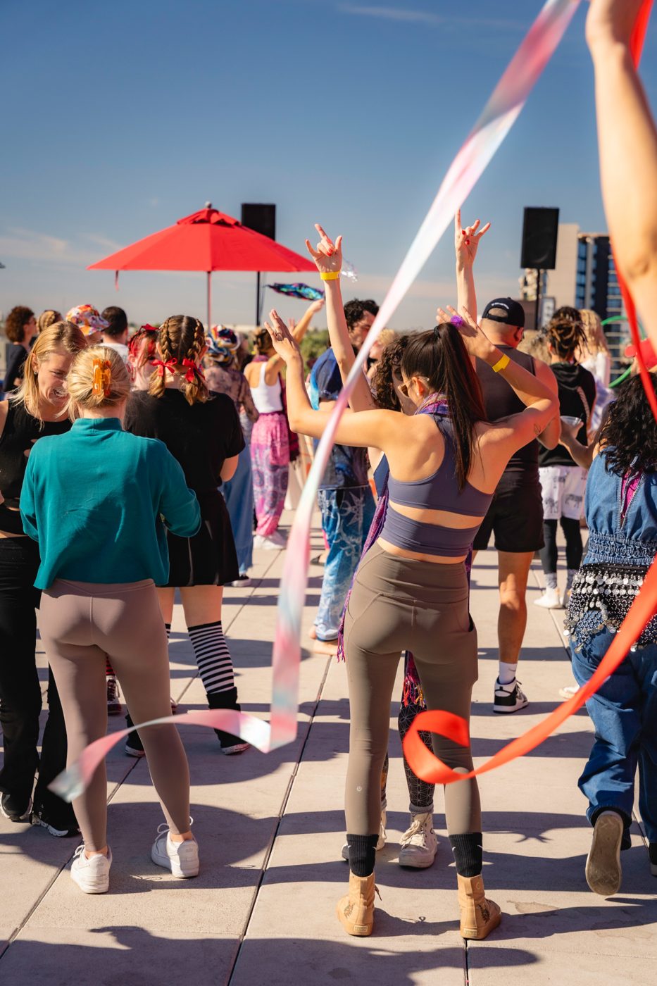Morning Rave crowd dancing outdoors with ribbons in daylight