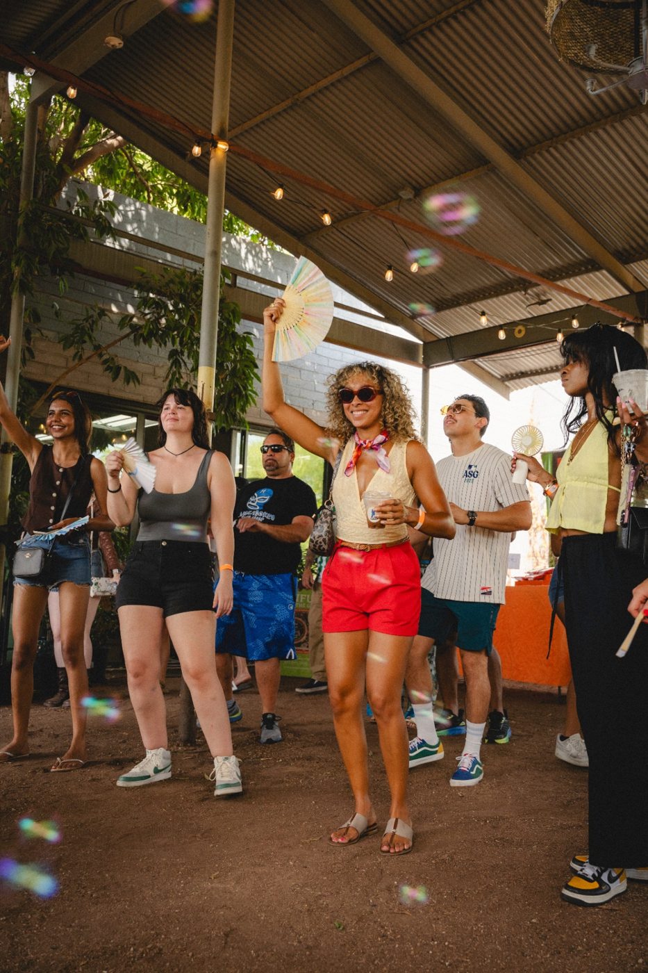 Attendees connecting and dancing under string lights at a Club Lumen pop-up